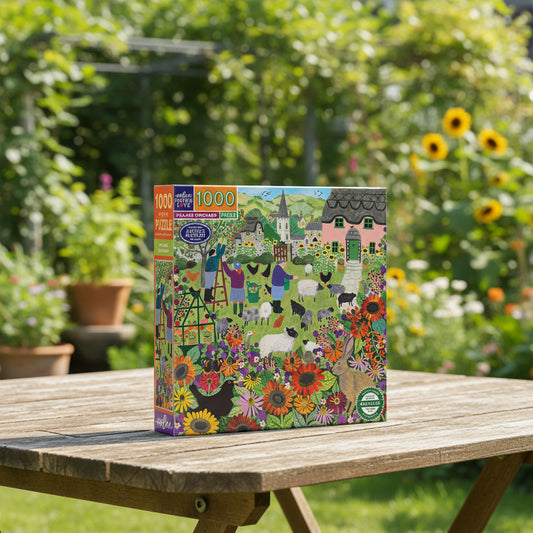Jigsaw puzzle box titled 'Village Orchard' with colorful illustration of a village scene.
